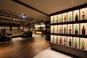una habitación con botellas de vino en la pared en Naruko Kanko Hotel en Osaki