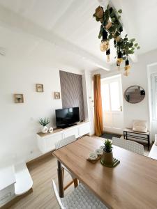uma sala de estar com uma mesa de madeira e uma televisão em La petite M em Tréméreuc
