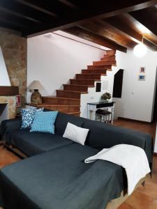 a living room with a blue couch and stairs at La casina in Vega del Ciego