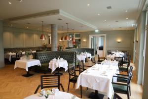 a dining room with white tables and chairs at Hotel Villa Sanct Peter in Bad Neuenahr-Ahrweiler