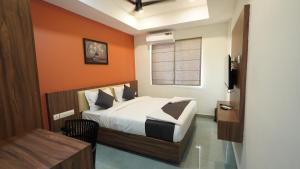科泽科德Hotel Hive Inn - Kozhikode的卧室里有一张床，墙壁是橙色的