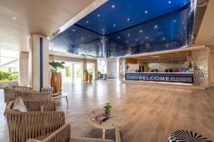 a lobby with a blue ceiling and chairs and a table at Boat Lagoon Yacht Marina Hotel in Ban Bang Khu