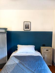 1 cama con cabecero azul en un dormitorio en Villa Mucellena, en Casole dʼElsa