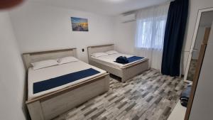 a bedroom with two beds and a window at Casa Bianca in Eforie Nord