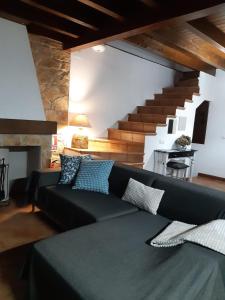 a living room with a black couch and stairs at La casina in Vega del Ciego