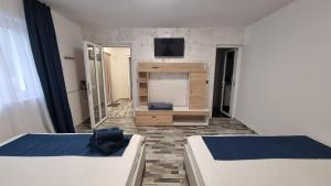 a room with two beds and a television in it at Casa Bianca in Eforie Nord +1 photo