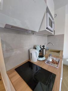 a small kitchen with a counter with a coffee maker at Studio L'échappée avec lit double et parking sous-sol privatif in Chartres