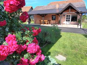 a house with pink roses in front of a yard at Guest house - studio apartman Marina in Karlovac
