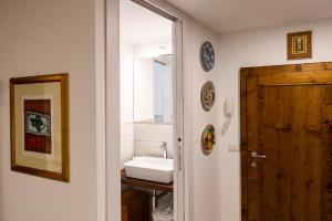 ein Badezimmer mit einem Waschbecken und einer Holztür in der Unterkunft Affittacamere Pozzo Bianco in Orvieto