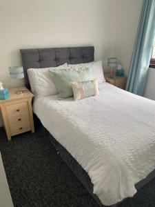 Argyll Apartment Loch Lomond في بالوتش: غرفة نوم بسرير كبير مع مواقف ليلتين