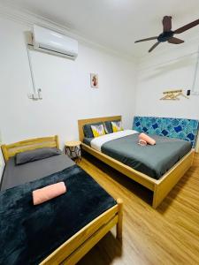 - une chambre avec 2 lits et un ventilateur de plafond dans l'établissement Melaka City Peacestay 3BR 7-11PAX 7min to Jonker St, à Malacca