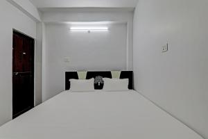 a white bedroom with a large bed in it at OYO Hotel R Glory in Patna