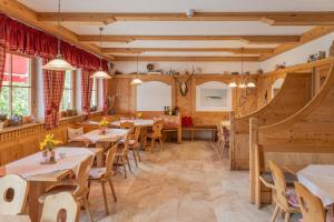 un restaurante con paredes de madera, mesas y sillas en isarwinkel, en Geretsried