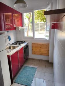 a kitchen with a sink and a stove and a window at Apartment 50 meters from the beach in Loutraki