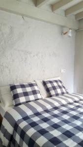 - un lit avec une couverture et des oreillers en damier bleu et blanc dans l'établissement Preciosa planta baja a pocos metros de la playa, à Palma de Majorque