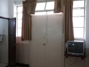 ein Bad mit einer weißen Tür und einem TV in der Unterkunft Hotel Centenario in Guatemala