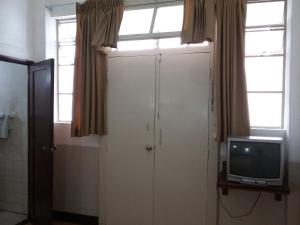 a bathroom with a white door and a tv at Hotel Centenario in Guatemala