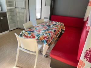 - une salle à manger avec une table et un canapé rouge dans l'établissement Camping Le Ruisseau, à Saint-André-de-Seignanx