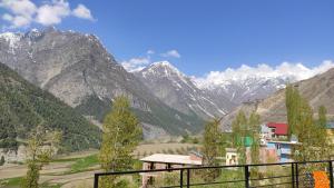 a view of a mountain range with a building at beheney Homestay in Kyelang