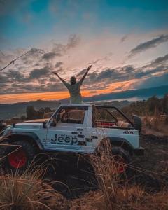 un hombre sentado en la parte trasera de un camión blanco en Bali Jeep Tour, en Kubupenlokan
