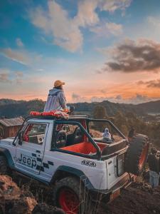 una persona sentada encima de un camión blanco en Bali Jeep Tour, en Kubupenlokan