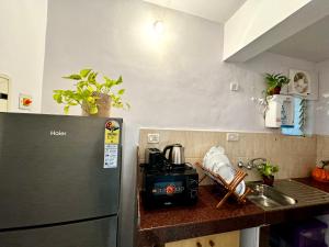 um balcão de cozinha com um frigorífico e um lavatório em LUSO Beach Homes Goa em Benaulim