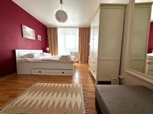 1 dormitorio con cama y pared roja en Le Petit Paris- Central , Dorobanți with a view, en Bucarest
