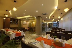una sala da pranzo con tavoli, sedie e luci di Apex Business Hotel a Kathmandu
