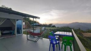 a balcony with chairs and a table with a view at Hawun Valley Kiulu in Tamparuli