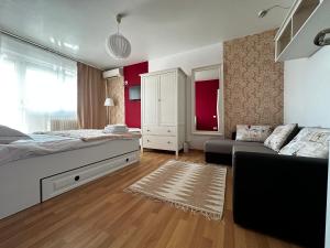 1 dormitorio con paredes rojas, 1 cama y 1 sofá en Le Petit Paris- Central , Dorobanți with a view, en Bucarest