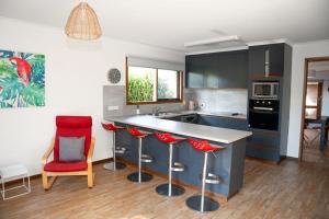 a kitchen with red bar stools and a counter at Port Bayou House in Port Campbell