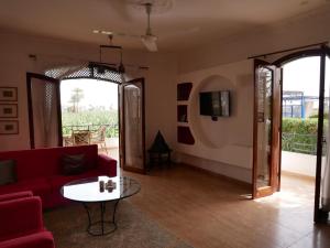 salon z czerwoną kanapą i stołem w obiekcie Villa Quiet Place w mieście Luksor