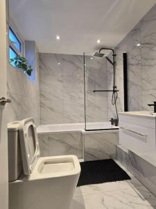 a white bathroom with a toilet and a sink at Lily in Blackpool
