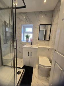 a bathroom with a toilet and a sink and a shower at Lily in Blackpool