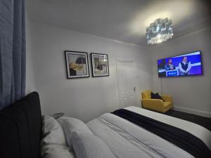 a bedroom with a bed and a tv on the wall at Lily in Blackpool