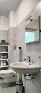 Baño blanco con lavabo y aseo en Casa vacanze "La Begonia", en Morbegno