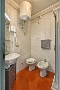 a bathroom with a toilet and a sink at Appartamento Panorama al Porto - Theater Home in Gargnano