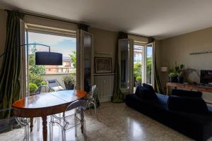uma sala de estar com uma mesa e um sofá em L'Attico vicinissimo all'Ospedale di Cuneo con grande terrazzo em Cuneo