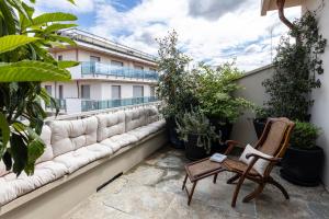 einen Balkon mit Sofa, Stühlen und Pflanzen in der Unterkunft L'Attico vicinissimo all'Ospedale di Cuneo con grande terrazzo in Cuneo