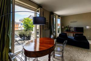 ein Wohnzimmer mit einem Tisch und einem Sofa in der Unterkunft L'Attico vicinissimo all'Ospedale di Cuneo con grande terrazzo in Cuneo