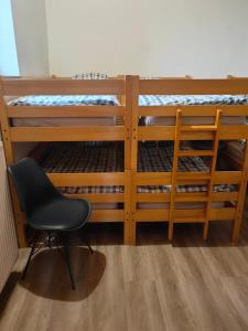 einen Stuhl in einem Zimmer mit 2 Etagenbetten in der Unterkunft Tumova koča na Slavniku in Podgorje