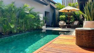 a pool with a table and chairs and an umbrella at Amalika Private Pool Villa Central to Everything in Gili Trawangan