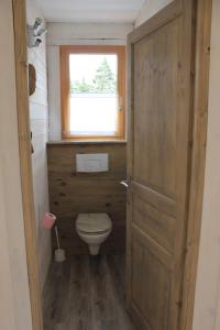 La salle de bains est pourvue de toilettes, d'une fenêtre et d'une porte. dans l'établissement La Poussada, maisons écologiques avec vue mer, à Lapalme