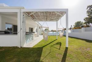 a white house with a yard with swings at Turquoise Waters Retreat in Perth