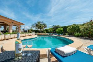 a bottle of wine on a table next to a swimming pool at Villa Son Ferriol in Palma de Mallorca