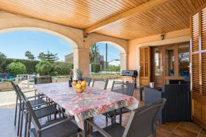 a dining table and chairs on a patio at Villa Son Ferriol in Palma de Mallorca