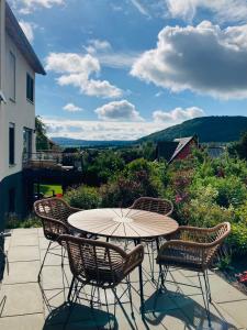 stół z krzesłami i parasol na patio w obiekcie Tiny House Wettelsheim w mieście Treuchtlingen