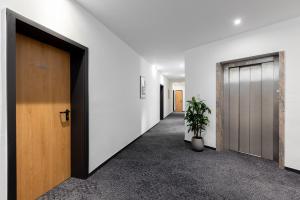 un corridoio con due porte e una pianta in vaso di Hotel Wegener a Mannheim
