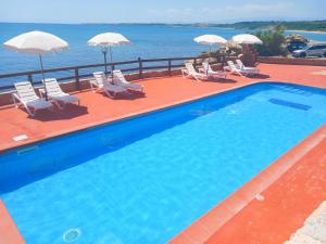 a swimming pool with chairs and umbrellas at Residence Poseidon Villaggio in Isola Capo Rizzuto