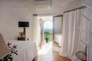 a bedroom with a bed and a large window at Can Quince de Balafia - Turismo de Interior in Sant Llorenç de Balafia